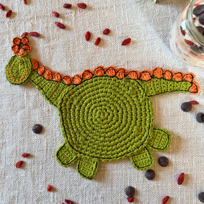 Full green crochet dinosaur with a round body, long neck, legs and tail