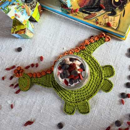 Full green dinosaur coaster with a jar placed on its round body