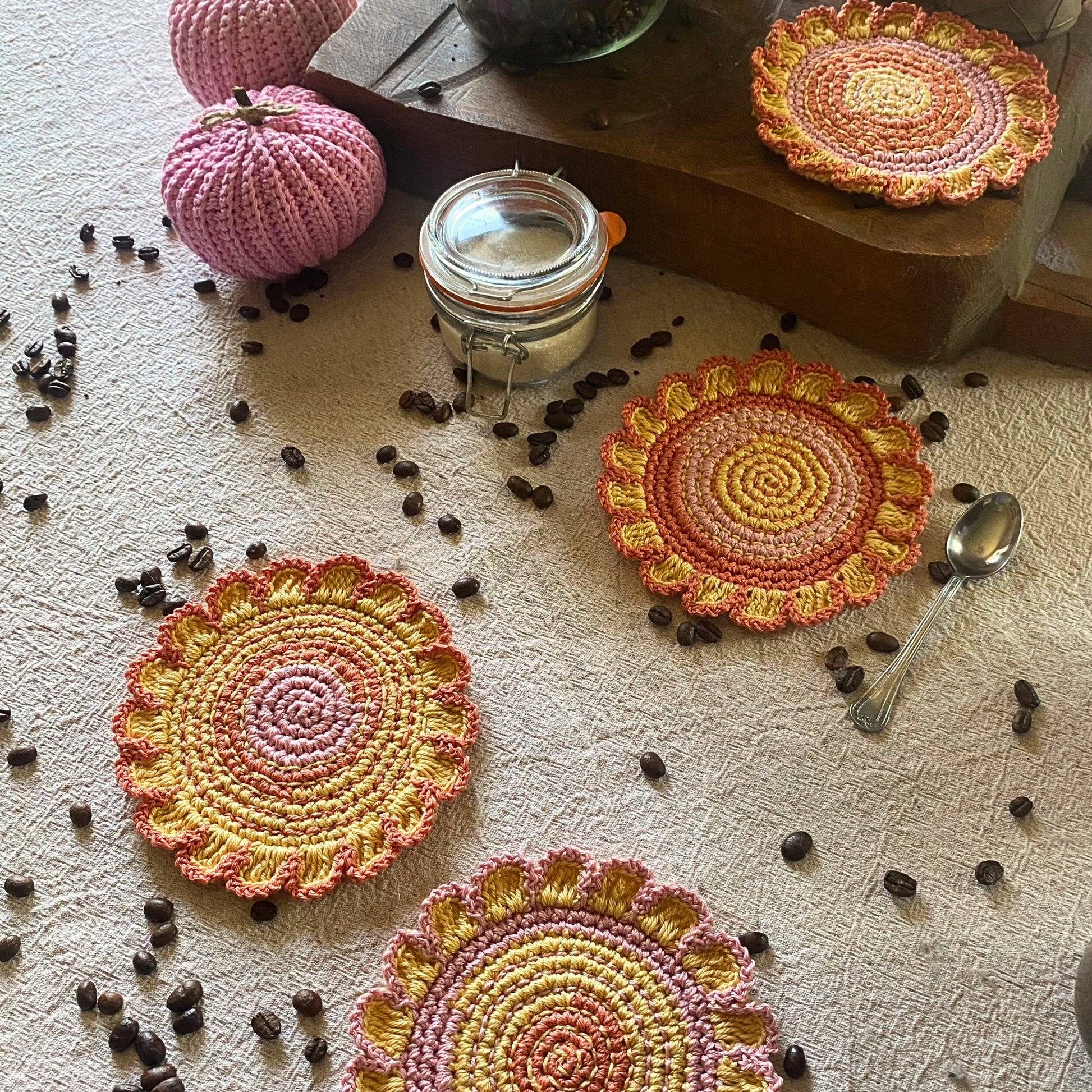 Handmade crochet flower-shaped coaster set of 4 in yellow, orange, pink and brown with embroidery