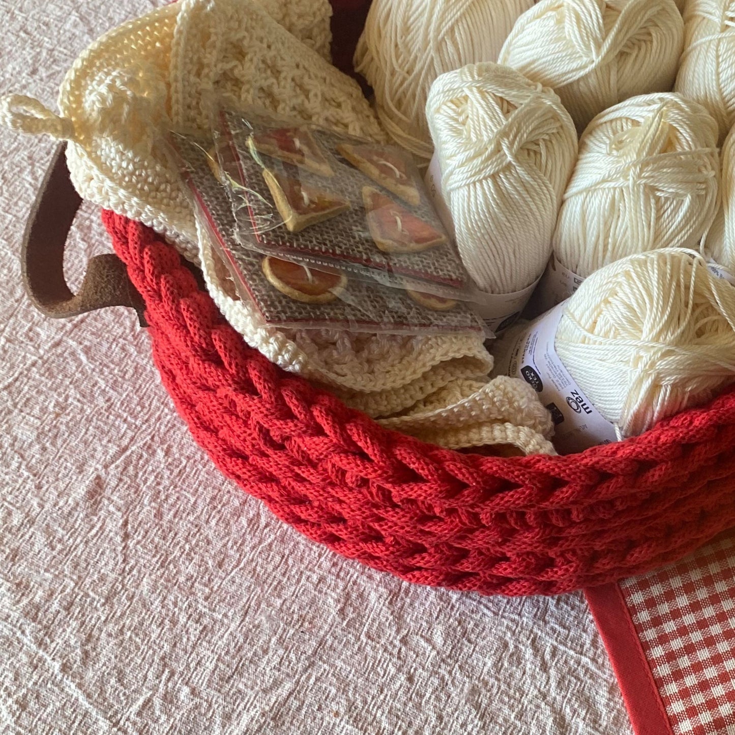 Red basket filled with white yarn 